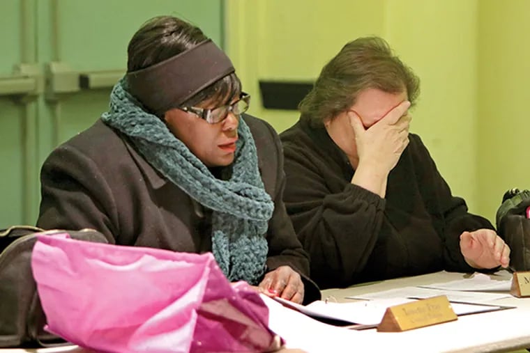 Colwyn Borough Councilwoman Martha Van Auken (right) reacts as Tonette Pray (left) reads the amount owed on a bill during a borough council meeting, Thursday, Feb. 19, 2015, at the borough hall in Colwyn, Pa. ( Joseph Kaczmarek / For The Inquirer )