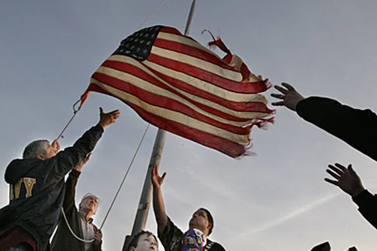 (Left-Right) Navy veteran Dan Rodgers of Horsham, Pa, Marvin Hume, 87, Jonathan Teiper, 6, of Mullica Hill and Dan Check of Villas Pull in the flag as it is lowered at Sunset Beach. (Elizabeth Robertson / Inquirer Staff)