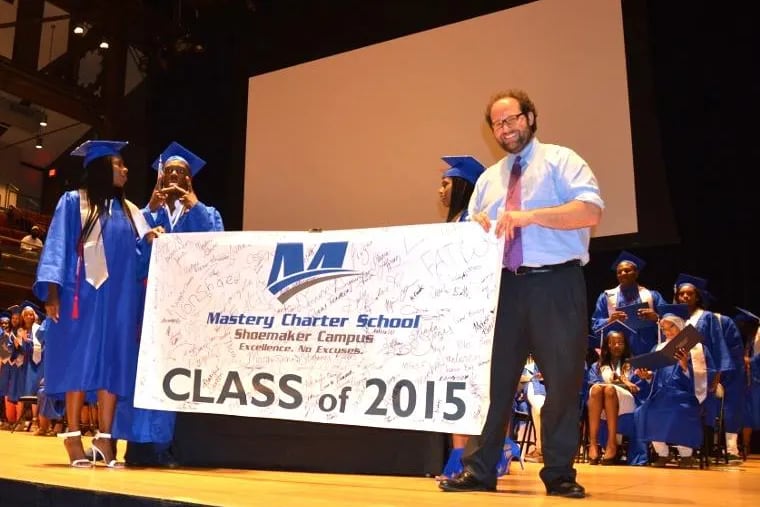Zachary Wright receives the Senior Class Flag at the 2015 graduation ceremony for Mastery Charter School Shoemaker Campus, where Sharif El-Mekki is principal.