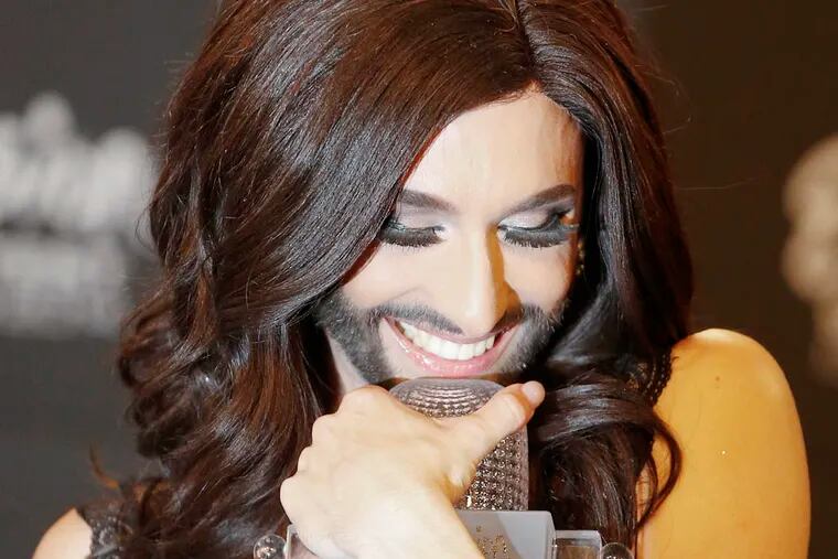 Singer Conchita Wurst representing Austria who performed the song 'Rise Like a Phoenix' hugs the trophy during a press conference after winning the Eurovision Song Contest  in the B&W Halls in Copenhagen, Denmark, Saturday, May 10, 2014.(AP Photo/Frank Augstein)