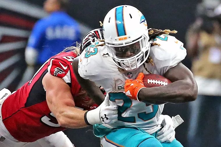 Miami Dolphins’ Jay Ajayi (23) runs the ball in the fourth quarter as Atlanta Falcons’ Brook Reed (50) reaches to tackle him on Sunday, Oct. 15, 2017 at the Mercedes-Benz Stadium in Atlanta, Ga. The Dolphins have traded Ajayi to the Philadelphia Eagles for a fourth-round draft pick.