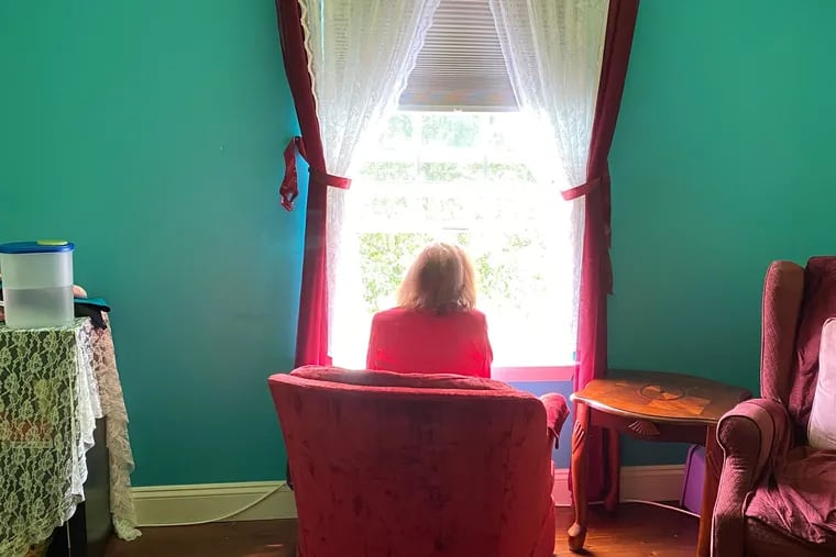 Rose Carfagno looks out her second-floor window during a recent visit with her son.  He did not come inside his sister's home because of coronavirus precautions.