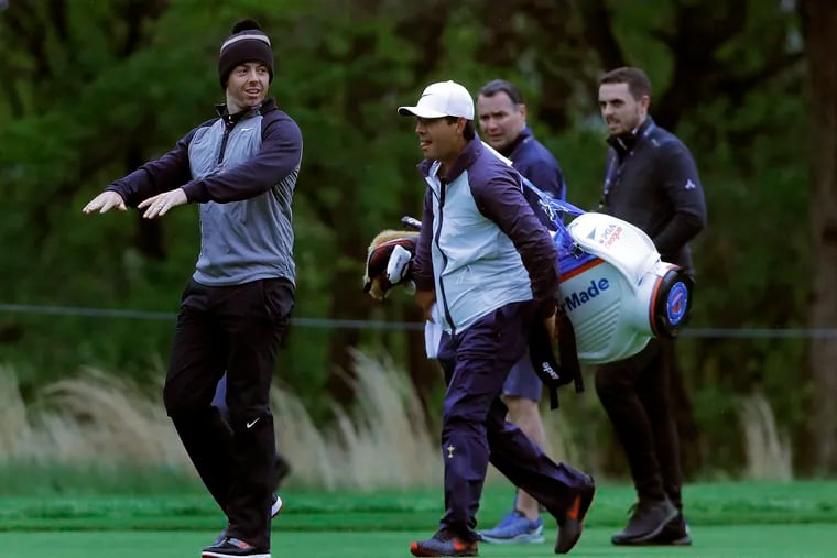 Northern Ireland's Rory McIlroy, left, walks along the 13th fairway during a practice round for the PGA Championship.
