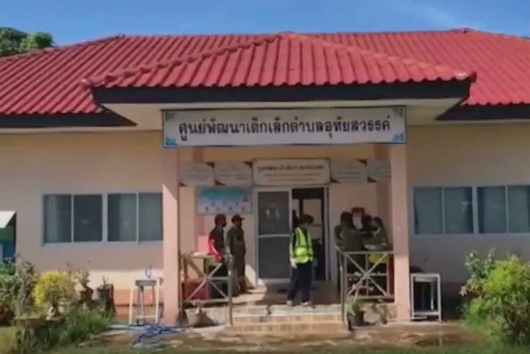 In this image taken from video, officials enter the site of an attack at a child-care center Thursday in the town of Nongbua Lamphu, Thailand.