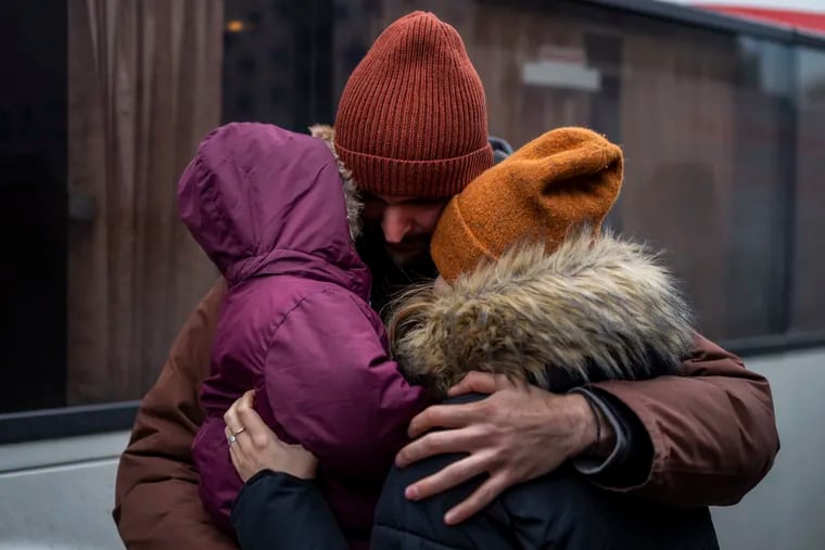 Ukrainian Pavlo Bilodid, 33, kisses his wife and daughter goodbye as they prepare to board a bus to Poland at Lviv bus main station, western Ukraine, Tuesday, March 1, 2022. Russian shelling pounded civilian targets in Ukraine's second-largest city Tuesday and a 40-mile convoy of tanks and other vehicles threatened the capital — tactics Ukraine’s embattled president said were designed to force him into concessions in Europe’s largest ground war in generations.