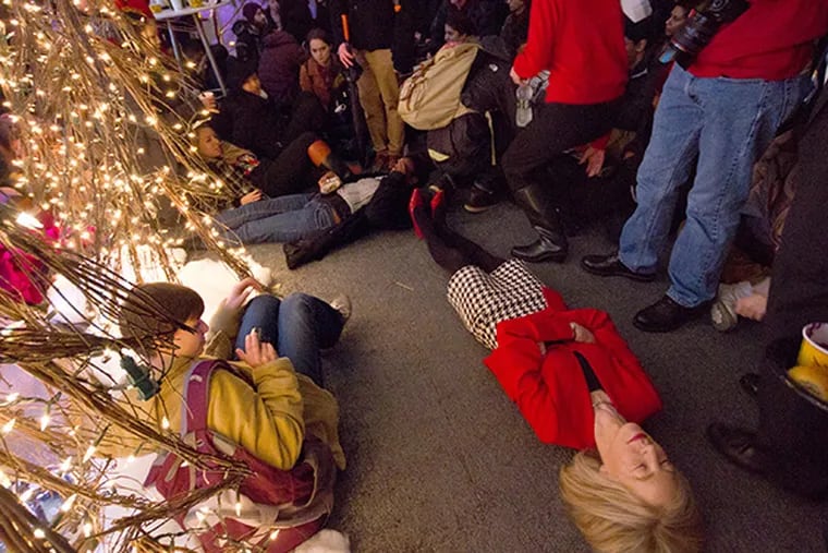 University of Pennsylvania President Amy Gutmann joins protesters in a "Die In" at a holiday party at her home.