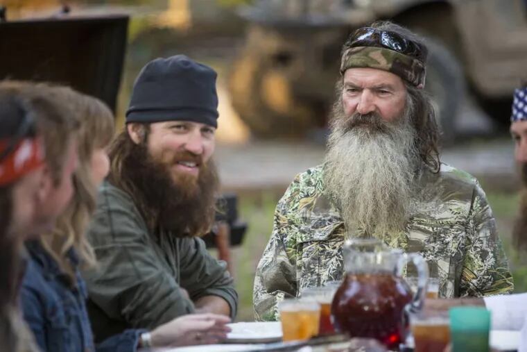 This undated image released by A&E shows Phil Robertson, flanked by his sons Jase Robertson, left, and Willie Robertson from the popular series "Duck Dynasty."   Phil Robertson was suspended last week for disparaging comments he made to GQ magazine about gay people.(AP Photo/A&E, Zach Dilgard)