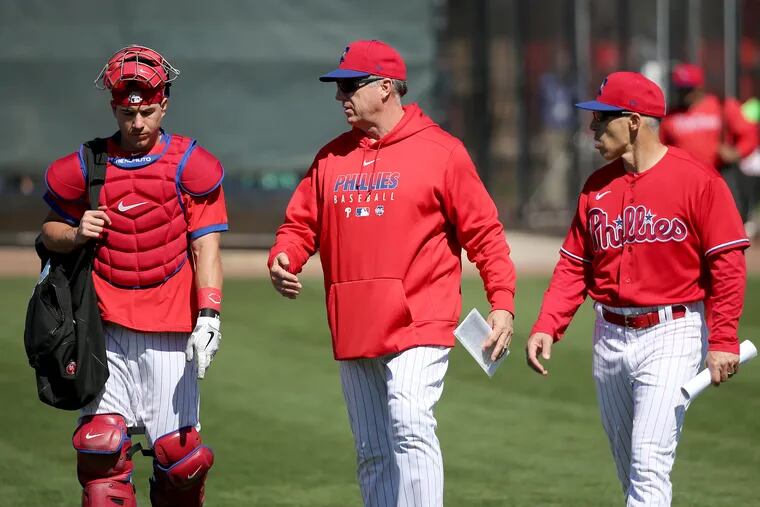 Phillies J. T. Realmuto, left, talks with bullpen coach Jim Gott, center, and manager Joe Girardi, right, during spring training.