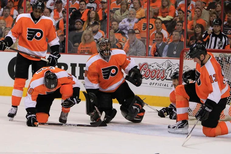 Flyers goalie Ilya Bryzgalov and teammates are stunned after the the Penguins' fourth goal. Bryzgalov was pulled after giving up five.