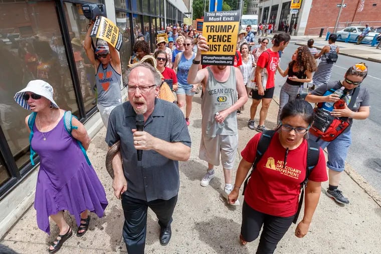 On Monday, Rabbi Shawn Zevit, with microphone, led the chants as a large group of protesters circled the block where ICE headquarters is located in Center City, part of a protest against the threat of mass arrests and deportations by the Trump administration.