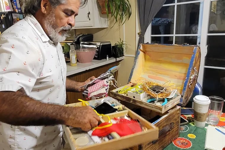 Rogelio Zavala busca en la caja de materiales recuperados que utiliza para crear su arte. Hace 37 años, Zavala se mudó de México a Avondale, Pensilvania y luego a Wilmington, Delaware donde él y todas sus hijas crean artesanías y arte.