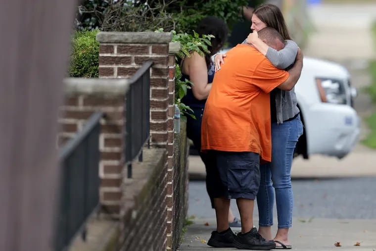 People embrace at the scene of the murder-suicide that claimed the life of veteran Philadelphia City Council staffer Linda Rios-Neuby on Friday.