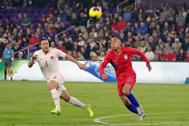 United States defender Sergiño Dest (right) keeps his eye on the ball as Canada's Samuel Piette gives chase.