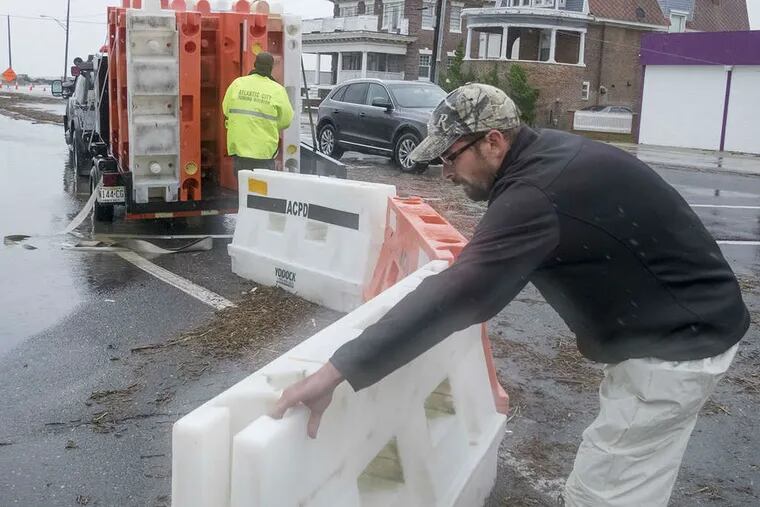 Workers barricade a road due to flooding in Atlantic City last week. (Ed Hille / Staff)
