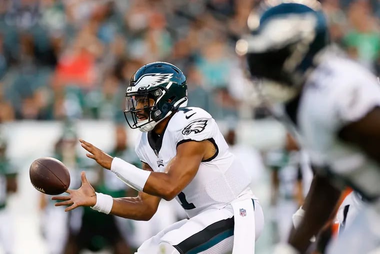 Eagles quarterback Jalen Hurts catching the snapped football during a preseason game against the New York Jets.