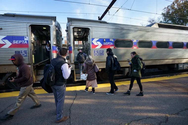 Commuters at the East Falls Regional Rail SEPTA Station board a train. Call-outs caused Regional Rail cancellations on Monday morning.