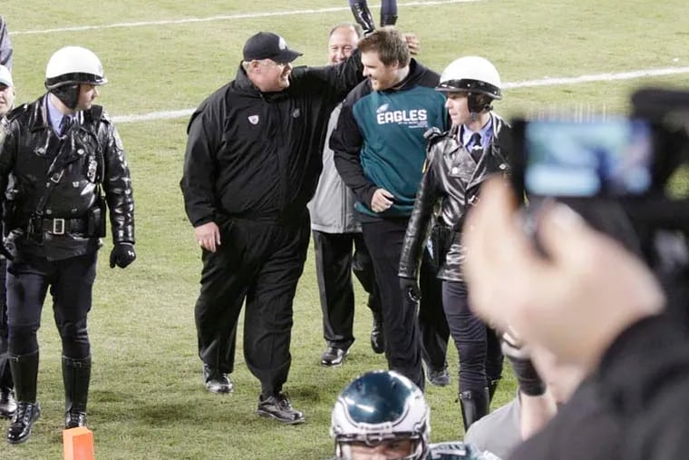 Eagles coach Andy Reid and son Garrett walking off the field after beating the Giants at Lincoln Financial Field on Nov. 21, 2010.