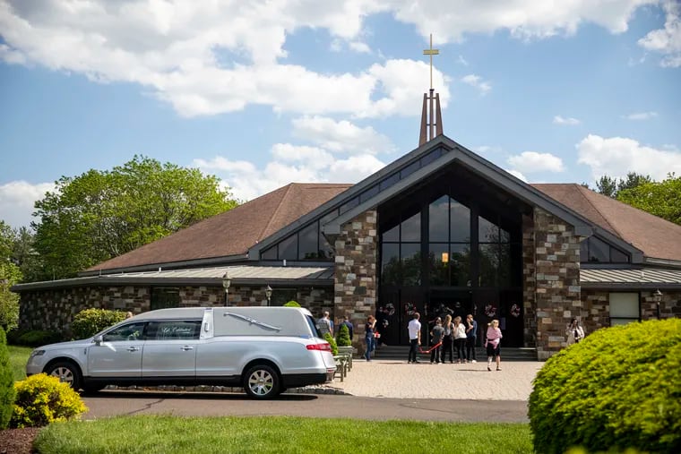 Neighbors and loved ones of Jeffery and Nelson Tini gather for the brothers' funeral mass on Tuesday at St. Andrew Catholic Church in Newtown. Prosecutors in Bucks County say the two brothers were killed by their mother as they slept in their beds May 2.