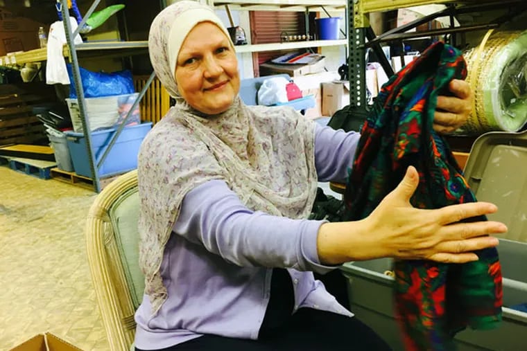 Renata Alkurdi of Narenj Tree Foundation, a Norristown-based charity, which is responding to the Syrian refugee crisis, folds a donated shirt destined for shipment to a Middle East refugee camp. (MICHAEL MATZA/Inquirer Staff)