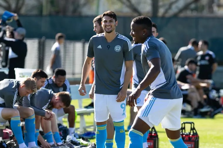 Julián Carranza (center) and Sergio Santos (right) smile on the bench during the Union's preseason opener against FC Cincinnati in Clearwater, Fla, on Friday.