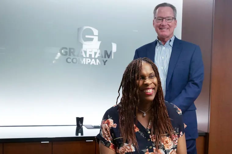 Bill Mitchell, chairman of The Graham Company, and Thomasina Justice pose for a photo at the Graham Company building in Center City.