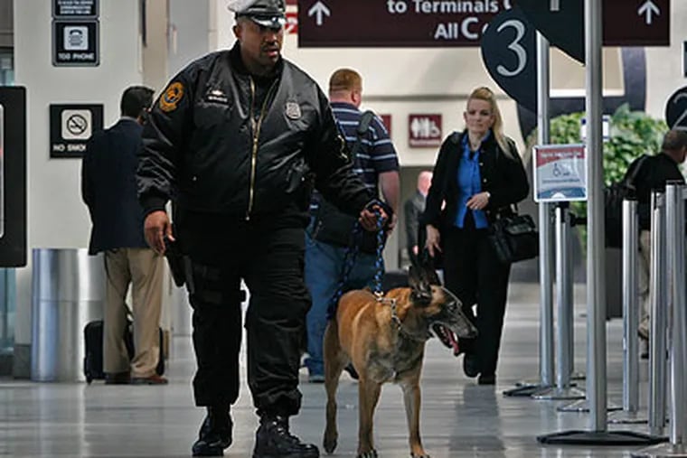 In a reassuring routine, K9 Officer Terry Wright patrols an airport concourse with Rex. (Alejandro A. Alvarez / Staff Photographer)