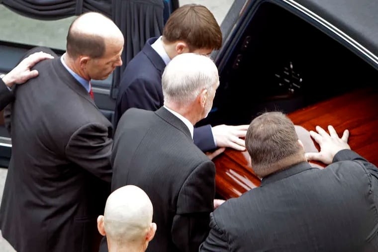 Pallbearers, including Joe Paterno's son, Scott (bottom right), place casket into the hearse before the funeral procession around the Penn State campus.