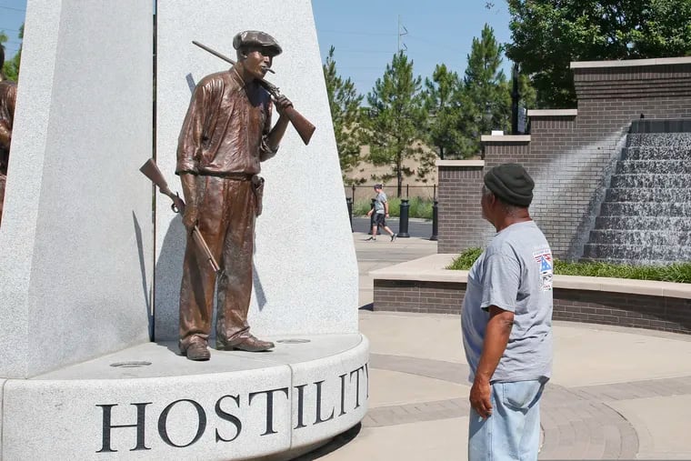 Donald Shaw looks at a sculpture in the John Hope Franklin reconciliation park in Tulsa, a few hundred yards and on the other side of what's historically the city's white-black dividing line, where President Donald Trump will rally Saturday.