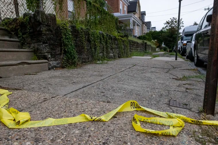 Philadelphia police crime scene tape left on sidewalk near victim's home, the scene of a fatal shooting along 100 block of East Washington Lane in Germantown section of Philadelphia early Monday morning.
