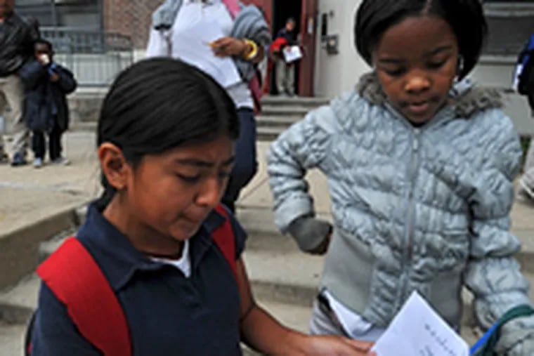 Fifth graders Jessica Medina (left) and Ahmyah Robinson read the superintendent&#0039;s note on the early dismissal.