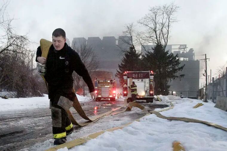 Riverton Firefighter John Quigg lays down hose. The plant is being torn down. No one was injured in the afternoon blaze.
