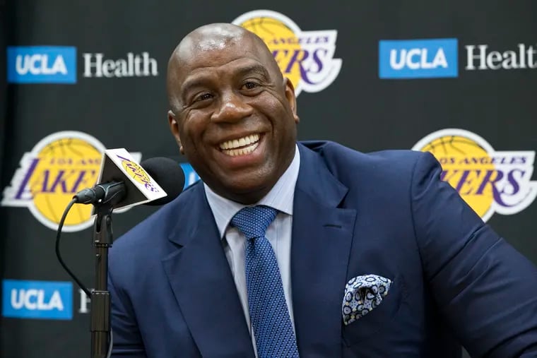 Los Angeles Lakers president of basketball operations, Earvin "Magic" Johnson, smiles as he introduces new draft players, Moritz Wagner, originally from Germany, the 25th pick in the 2018 NBA Draft and guard Sviatoslav Mykhailiuk, originally from Ukraine, at the UCLA Health Training Center in El Segundo, Calif., Tuesday, June 26, 2018. Magic Johnson is betting his job on his free-agent recruiting skills for the Los Angeles Lakers. Johnson says he will step down as the Lakers' president of basketball operations if he can't persuade an elite free agent to sign with his club within the next two summers. (AP Photo/Damian Dovarganes)