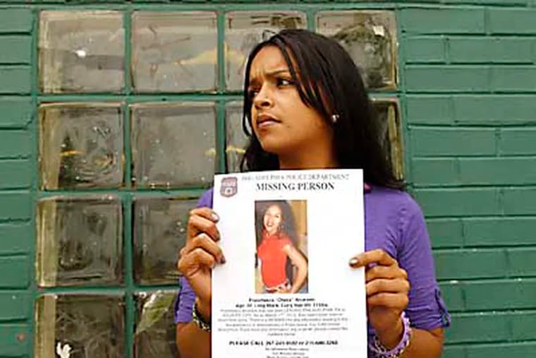 A woman referring to herself as "Mia" holds a missing person poster of her younger sister Franchesa "Cheka" Alvardo at the Piccoli Park and City Recreation Center in the Juniata section of Philadelphia on Wednesday, May 30, 2012.  ( Yong Kim / Staff Photographer )