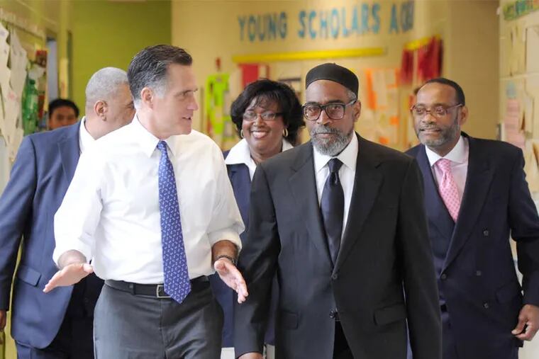 Universal-Bluford, one of two charters selected for closure, is run by a nonprofit founded by music mogul Kenny Gamble (seen here touring the school in 2012 with Mitt Romney).
