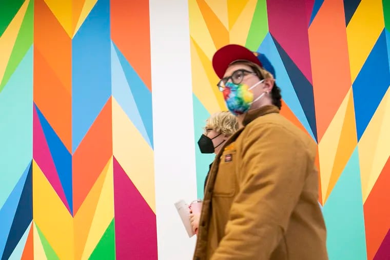 Masked visitors walk past the colorful walls outside of the Elegy exhibit inside the Philadelphia Museum of Art in March.