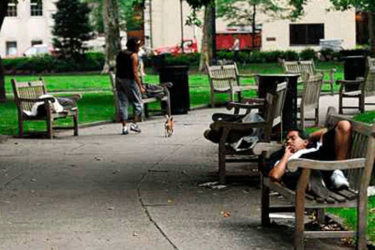 Rittenhouse Square is a summertime magnet for the homeless. On a recent morning, nearly two dozen homeless were asleep on benches. (Sarah J. Glover / Inquirer)