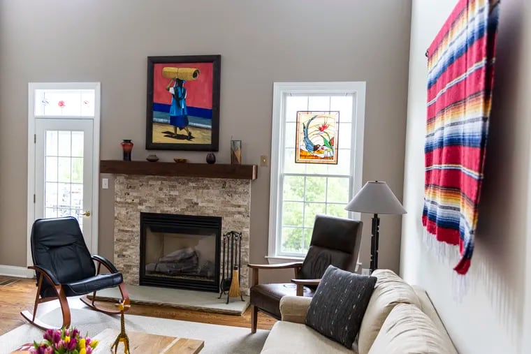 A painting from Oaxaca, Mexico, hangs over their fireplace in the living room in the home of Jayme Trott and Bud Johnson, in Holland, Pa., on Tuesday, April 2, 2023.