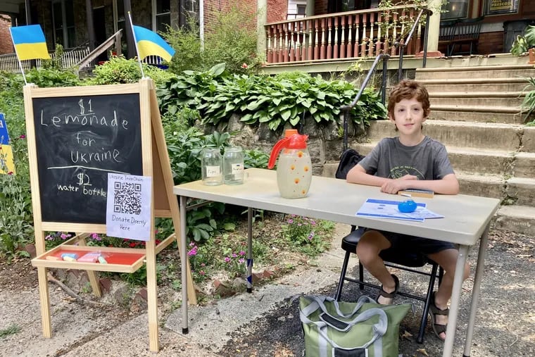 Yofi Knizhnik, age 9, awaits customers at his lemonade stand, which he set up outside his Cedar Park home to help raise money to support Ukraine against the Russian invasion.