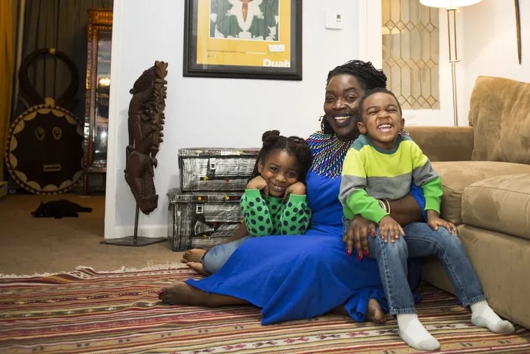 Celebrity hair stylist Syreeta Scott and her children, Parker Amaru Scott, and Eliam Amaru Scott (right) sit in her living room around various pieces of art. Scott’s home is decorated with art she has obtained while traveling for work and for pleasure.