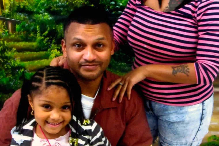 At Graterford, in front of a prison-supplied park-like backdrop, inmate Marcus Perez poses with his granddaughter Khylei, 6.