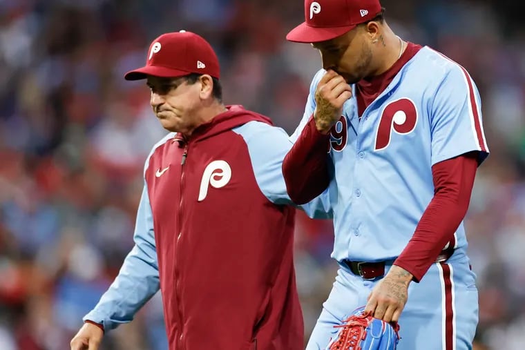 Phillies pitcher Taijuan Walker exits the game with manager Rob Thomson after Walker got hit by a line drive off the bat of New York Mets Starling Marte in the fourth inning.