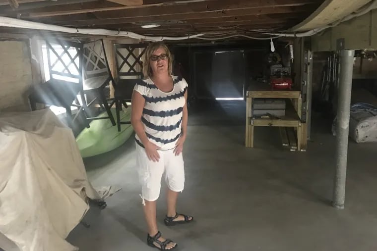 Kathy Culbertson, 51, of Ventnor Heights, stands, almost, in the ground floor of her house, which took in three feet of water during Sandy. Insurance wouldn’t cover, and repairs paid for by a state grant rendered the former in-law suite useless.