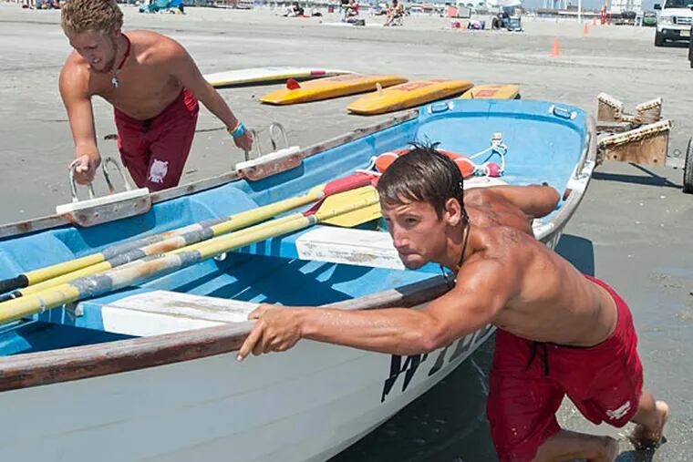Scott Mackin (left) and Ryan Carlin, both Council Rock High School
athletes and Wildwood NJ beach lifeguards, launch a rescue boat during
an exercise routine. (Ron Tarver/Staff Photographer)