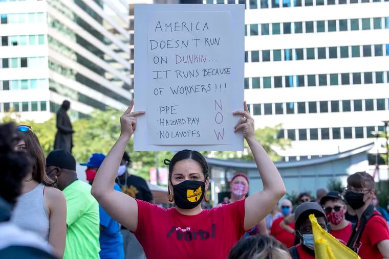 An unidentified woman holds a sign during a Labor Day rally at Philadelphia City Hall on Monday, Sept. 7, 2020. Philadelphia workers rally for personal protective equipment, hazard pay, and no cuts/no layoffs on Labor Day.
