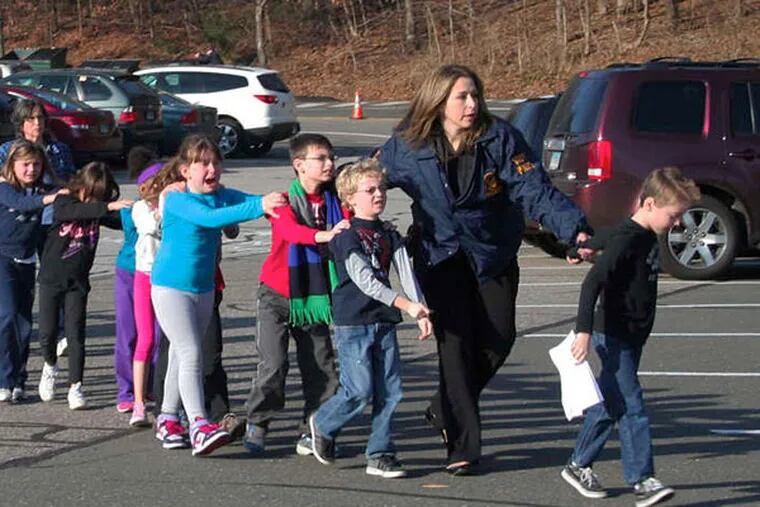 Saving the innocents: Friday's haunting image of state police leading a line of children from Sandy Hook Elementary School in Newtown, Conn.
