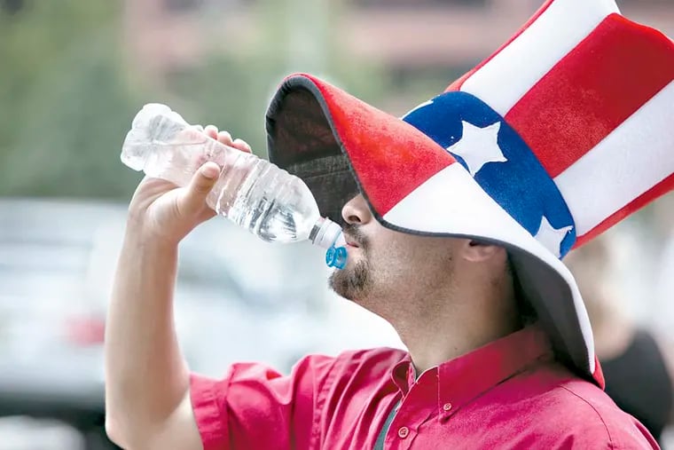 Eric Idelson, 22, of Richboro, takes a break from hawking tours on Independence Mall to hydrate himself with a bottle of water.