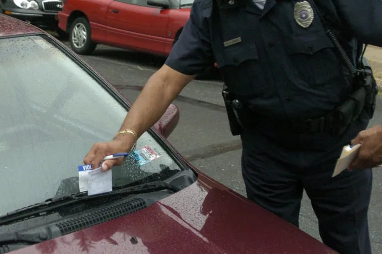 A Temple University police officer issues a parking ticket on the school's campus.