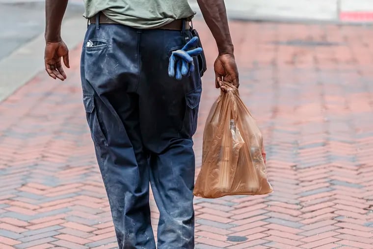 A pedestrian carries food items in a plastic bag in June 2019.