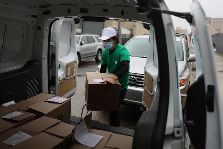 Driver Emir Lin loads customer boxes into a van at the RiceVan distribution facility just north of Philadelphia's Chinatown on Wednesday, March 31, 2021. RiceVan is a startup that delivers restaurant food and groceries — mostly from Chinatown businesses — to homes beyond the radius of typical delivery services, including as far as Delaware, New Jersey, and the Lehigh Valley.