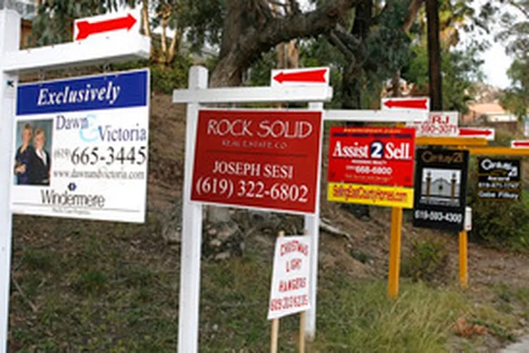 Multiple signs advertise homes for sale in San Diego amidthe housing slump. In November, 647,000 new homes were reported sold nationwide, a 9 percent dip from October.